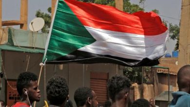 العلم السوداني مرفوعا خلال احتجاجات تطالب بحكم مدني