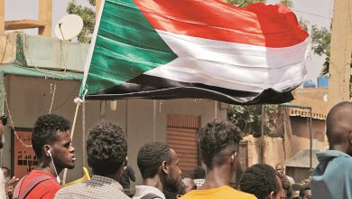 محتج يرفع علم السودان خلال تظاهرة في الخرطوم (أرشيفية)