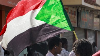 رجل يحمل علم السودان في مظاهرة مدنية في الخرطوم.